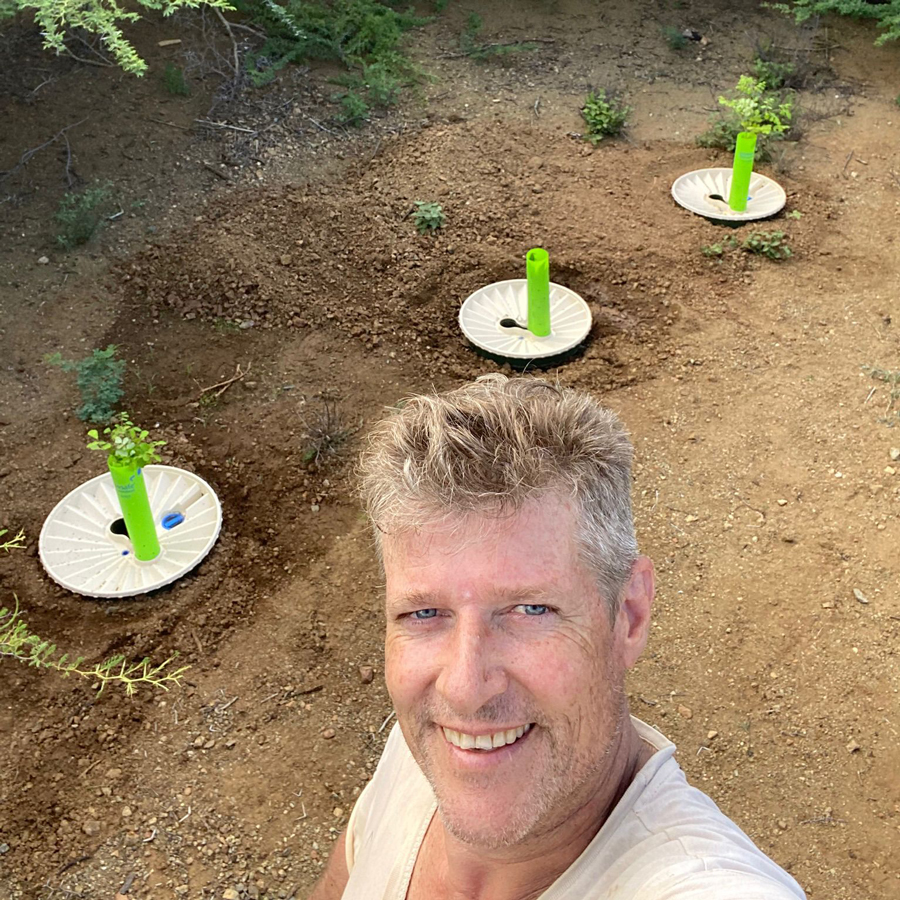 Egbert maakt een selfie in de tuin met waterboxxen en bomen